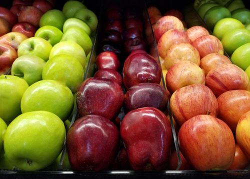 スーパーマーケットに並ぶ赤と緑のリンゴ