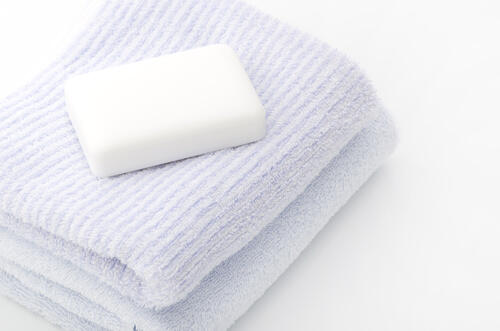 タオルの上に置かれた、清潔な固形石鹸の写真