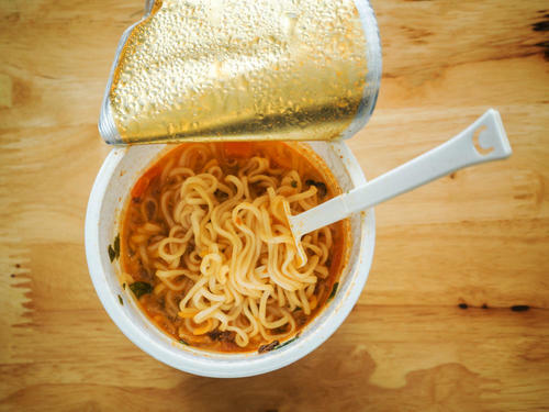 カップ麺とプラスチックフォークの画像