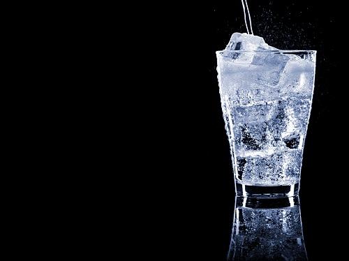 氷を入れたグラスに清涼飲料を注ぐ
