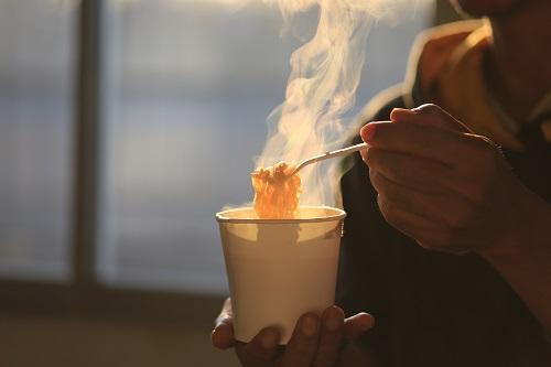 カップ麺を食べようとしている男性の画像