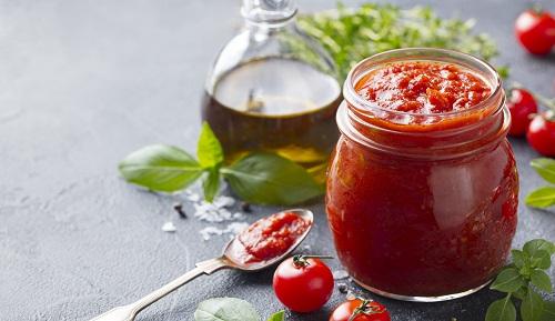 新鮮なハーブ、トマト、オリーブオイルが入ったガラス瓶に入った伝統的なトマトソース