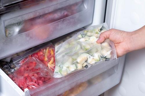 冷凍庫と冷凍野菜、冷凍庫から食材を取り出す