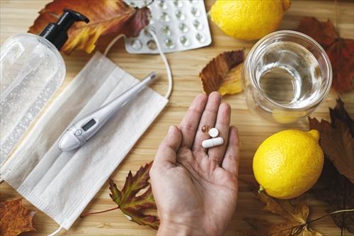 ビタミンD、ビタミンC、亜鉛の錠剤を持った手