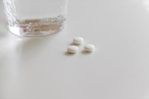 白い錠剤とグラスの水