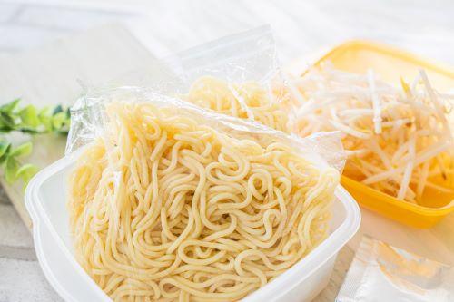 未開封の焼きそば麺とプラスチック製保存容器の画像