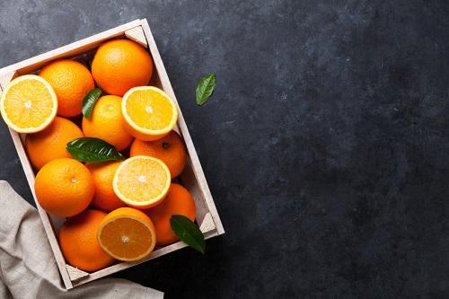 石のテーブルの木製のボックスで新鮮なオレンジ色の果実