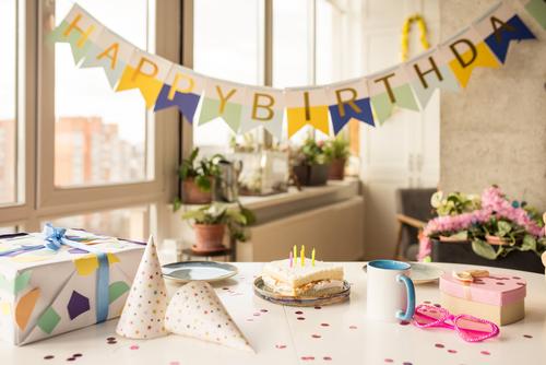 キャンドル、風船、色付きの装飾が施されたバースデー ケーキと誕生日パーティー テーブル