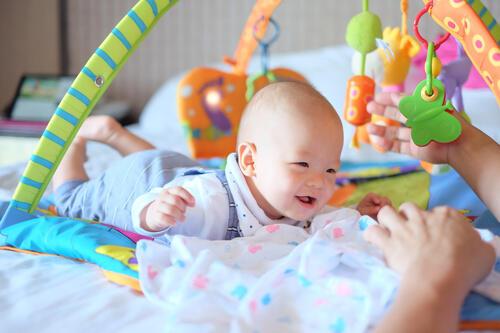 親と遊ぶ笑顔の赤ちゃんの写真
