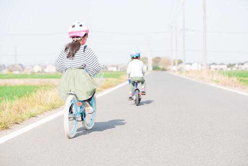 自転車でお出かけする子ども(きょうだい)の写真