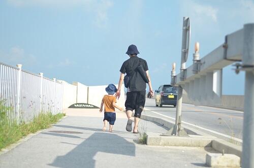 パパと手をつないで歩く子どもの写真