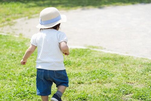 庭で遊ぶ子どもの後ろ姿の写真