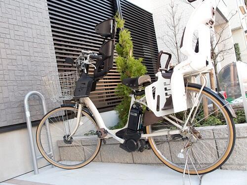 チャイルドシートが付いた白い電動自転車の写真