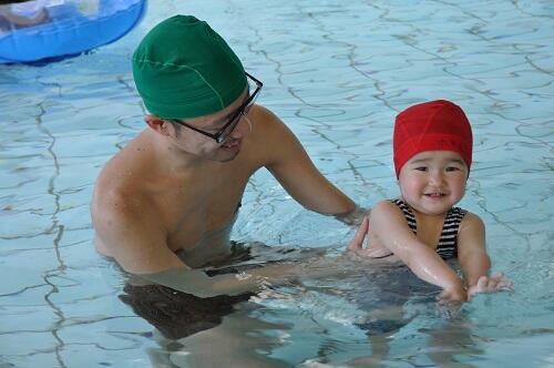 パパと楽しそうにプールで遊ぶ子どもの写真