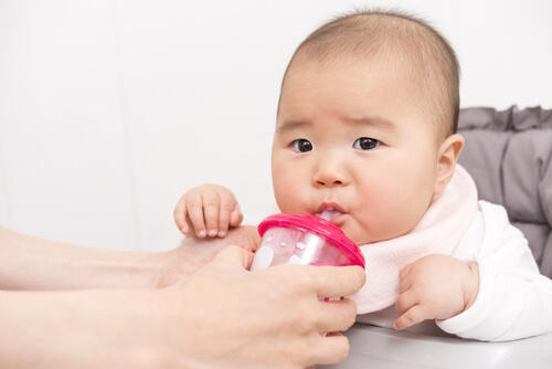 湯冷ましを飲む赤ちゃんのイメージ写真