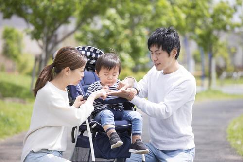 ベビーカーに乗っている子どもと両親の写真