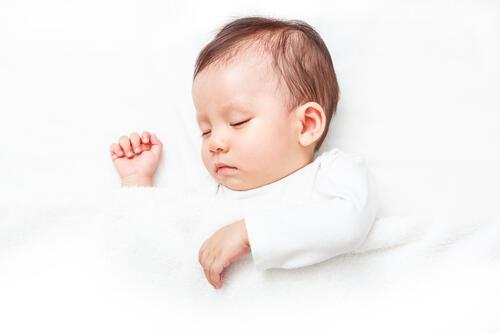 パジャマを着て眠る赤ちゃんのイメージ写真