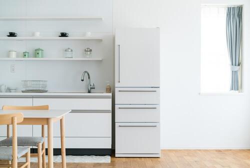 白い冷蔵庫が置いてあるキッチンの写真