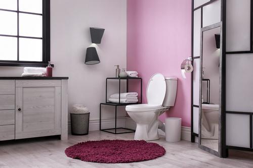 ピンクのアクセントクロスが貼られたおしゃれなトイレの写真