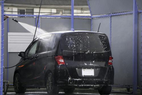 高圧洗浄式のセルフ洗車機で車を洗っているところの写真