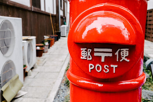 昔ながらの丸い郵便ポストの写真