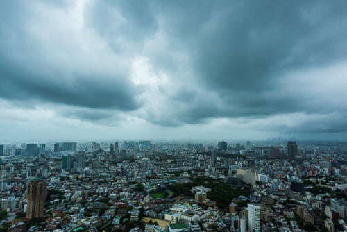 台風の前触れのような暗く曇った都会の空の写真