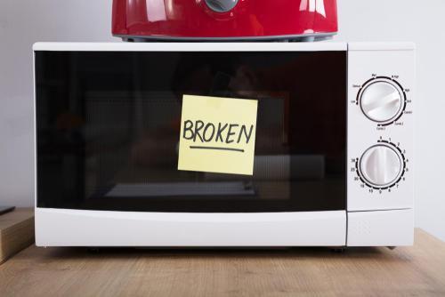 「Broken」の文字が貼ってある電子レンジの写真