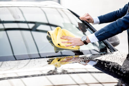 洗車した車を拭いている男性のイメージ写真
