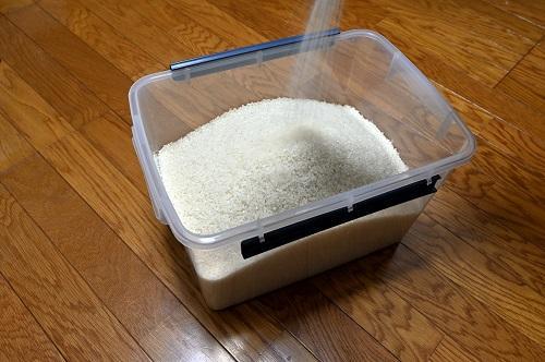 米びつに米を移しているところの写真