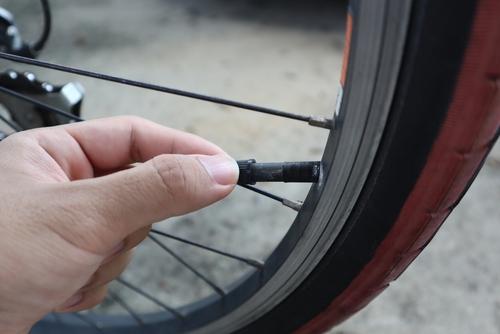 自転車のタイヤのバルブ（プランジャー）を引き抜こうとしているところの写真