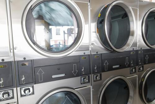 洗濯物が回転しているコインランドリーの大型乾燥機の写真