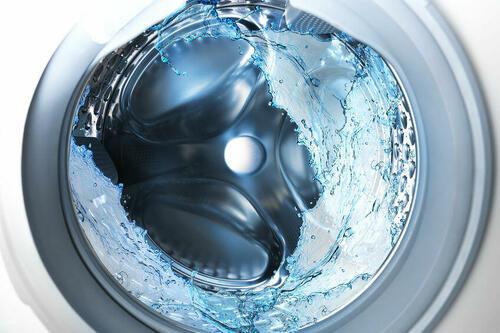 回転するドラム式洗濯機の洗濯槽の写真