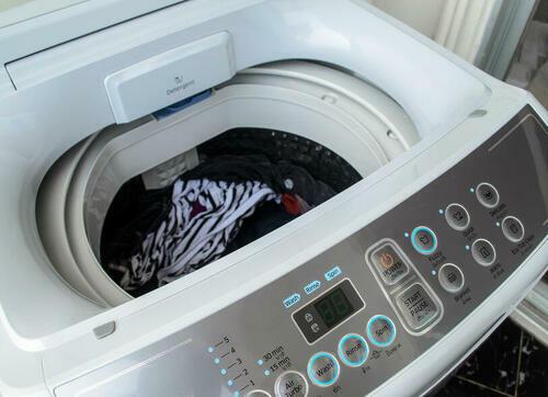 洗濯物が入った縦型洗濯機の写真