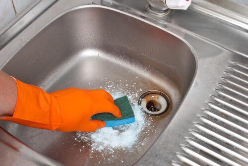 ハイドロハイターをイメージした粉末洗剤とスポンジでシンクを掃除しているところの写真