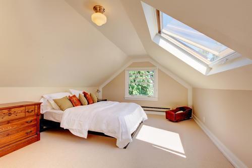 天窓から明るい光が差し込む屋根裏部屋の写真