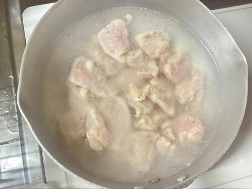 沸騰直前の湯に片栗粉でコーティングした鶏むね肉を入れる