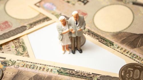 お金に囲まれた老夫婦の人形