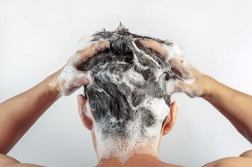 頭を洗う男性の後ろ姿の写真