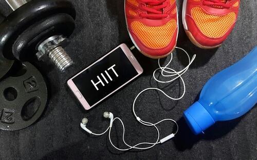 「HIIT」と書かれたスマートフォンと運動グッズの写真