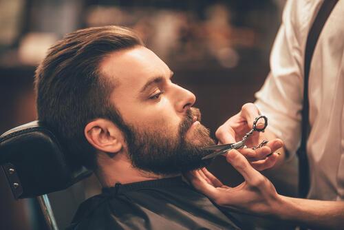 美容院で髭のお手入れをしてもらう男性の写真