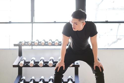 膝に手をつく男性の写真