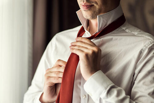ネクタイを結ぶ男性の写真