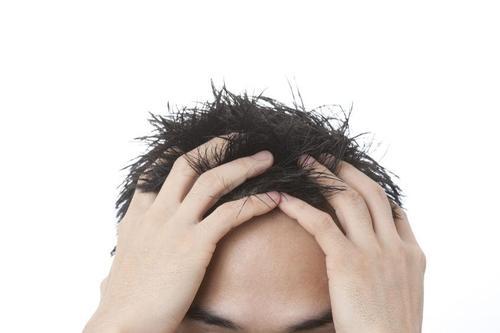 ひどい寝癖に頭を抱える男性のイメージ写真