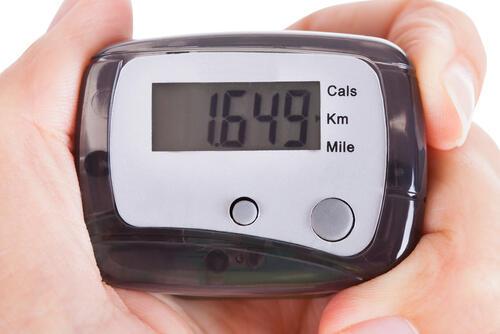 距離や消費カロリーの計測器を持つ手