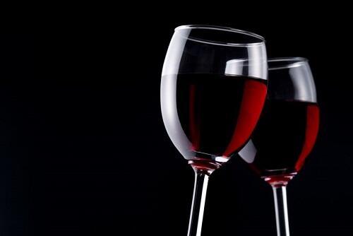 真っ暗な背景と、グラスに入った赤ワインの写真