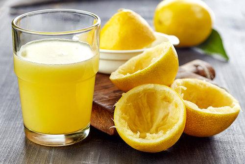 搾りたてのレモンとグラスに入ったレモン果汁