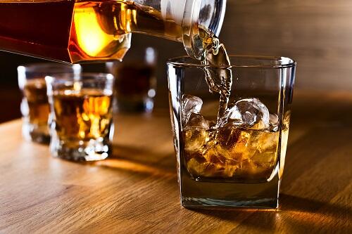 スコッチウイスキーをグラスに注いでいるところのイメージ写真